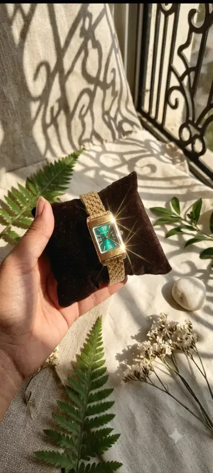 Swaorna emerald dial square watch on a velvet pillow